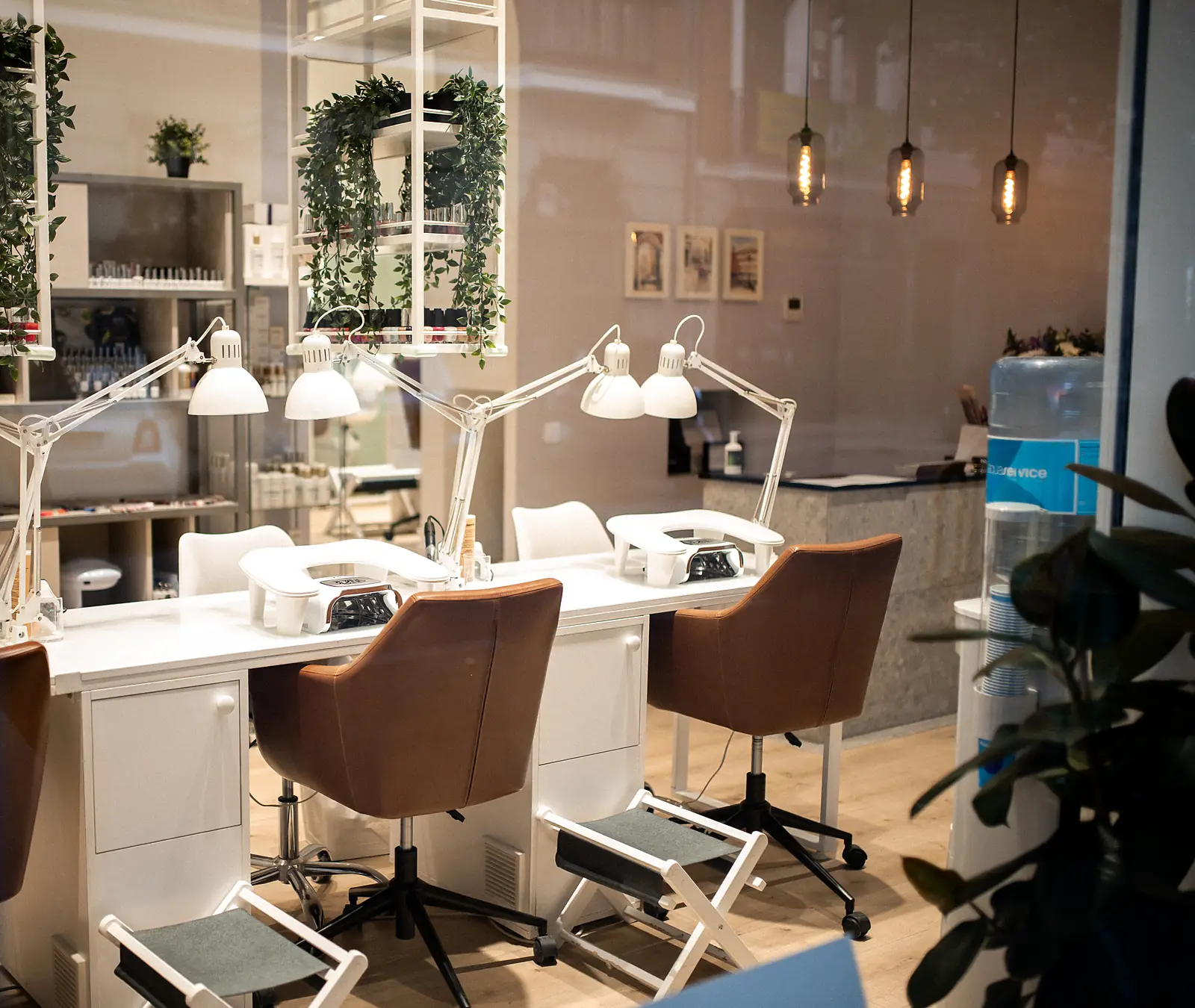Маникюрные столы с белыми лампами и кожаными креслами в салоне Nails Star